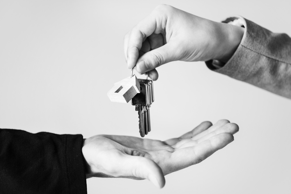 Muž předává klíče od nemovitosti jiné osobě.